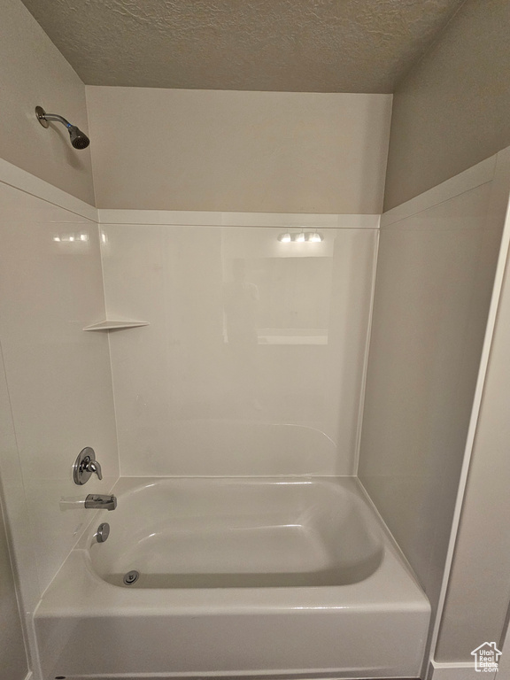Full bathroom featuring bathing tub / shower combination and a textured ceiling