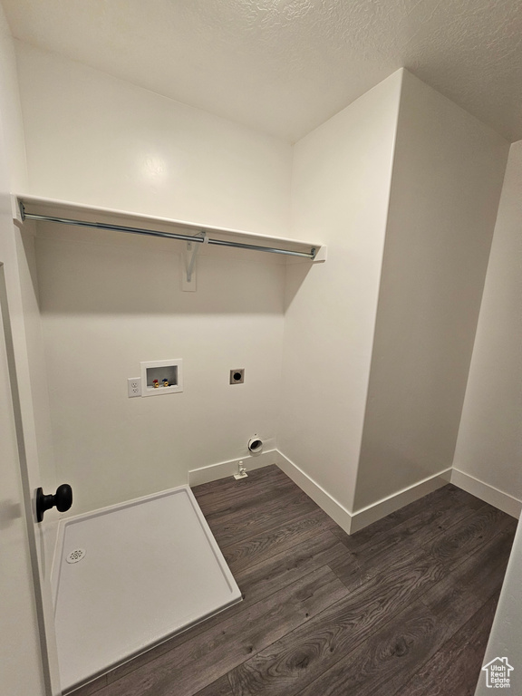 Washroom with dark wood-style flooring, washer hookup, hookup for an electric dryer, baseboards, and a textured ceiling