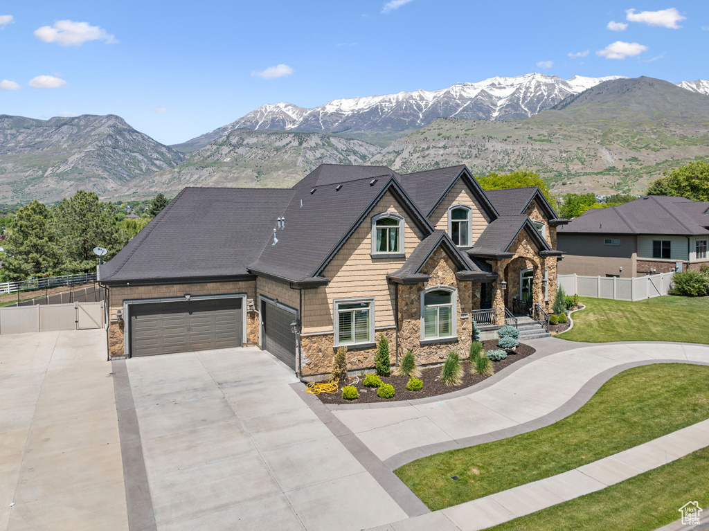 View of front of house with stone siding, concrete driveway, and a mountain view