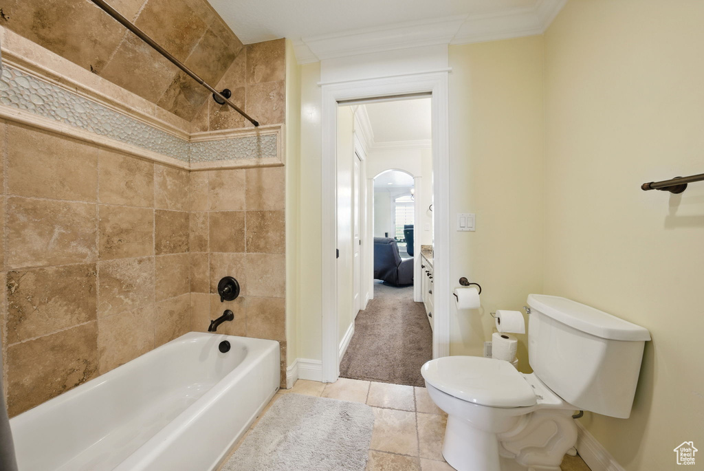 Bathroom featuring crown molding, shower / tub combination, toilet, baseboards, and tile patterned flooring
