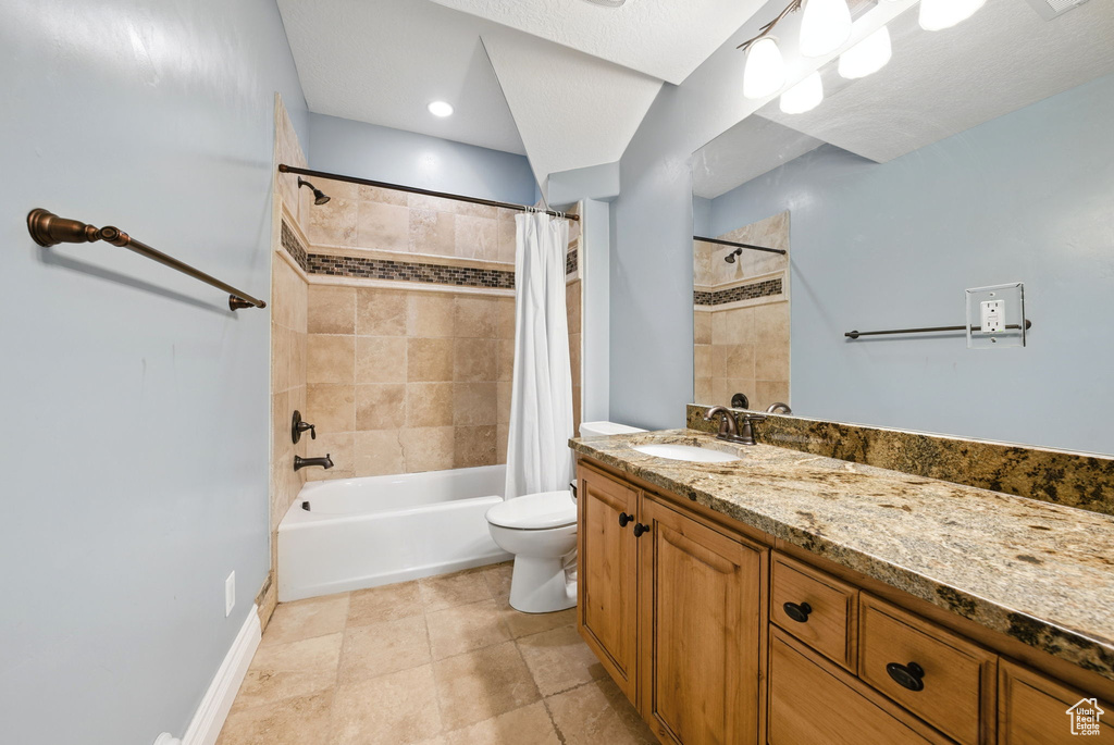 Full bathroom with toilet, shower / tub combo with curtain, vanity, baseboards, and tile patterned floors