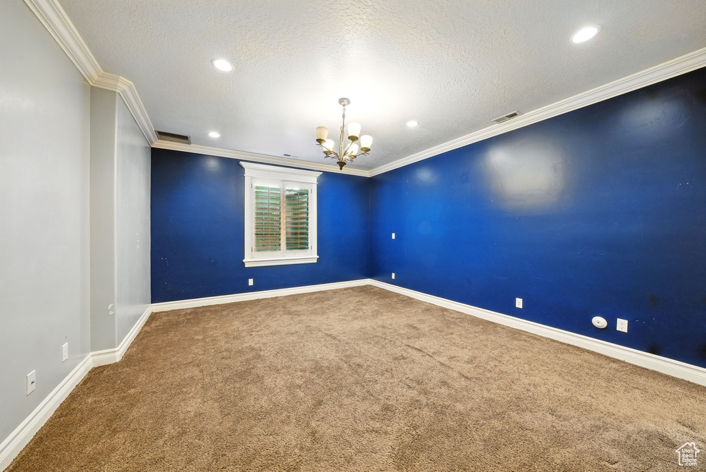 Carpeted spare room featuring a chandelier, baseboards, ornamental molding, recessed lighting, and a textured ceiling