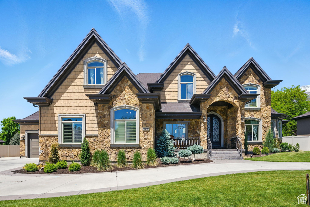 Craftsman house featuring stone siding and driveway
