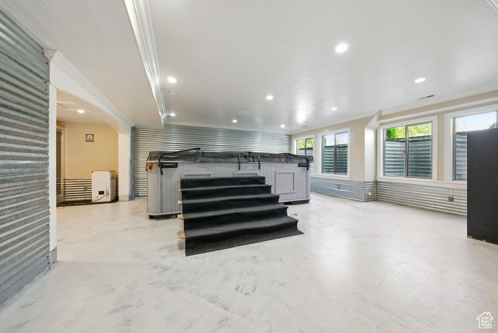 Living room featuring ornamental molding, recessed lighting, and concrete floors