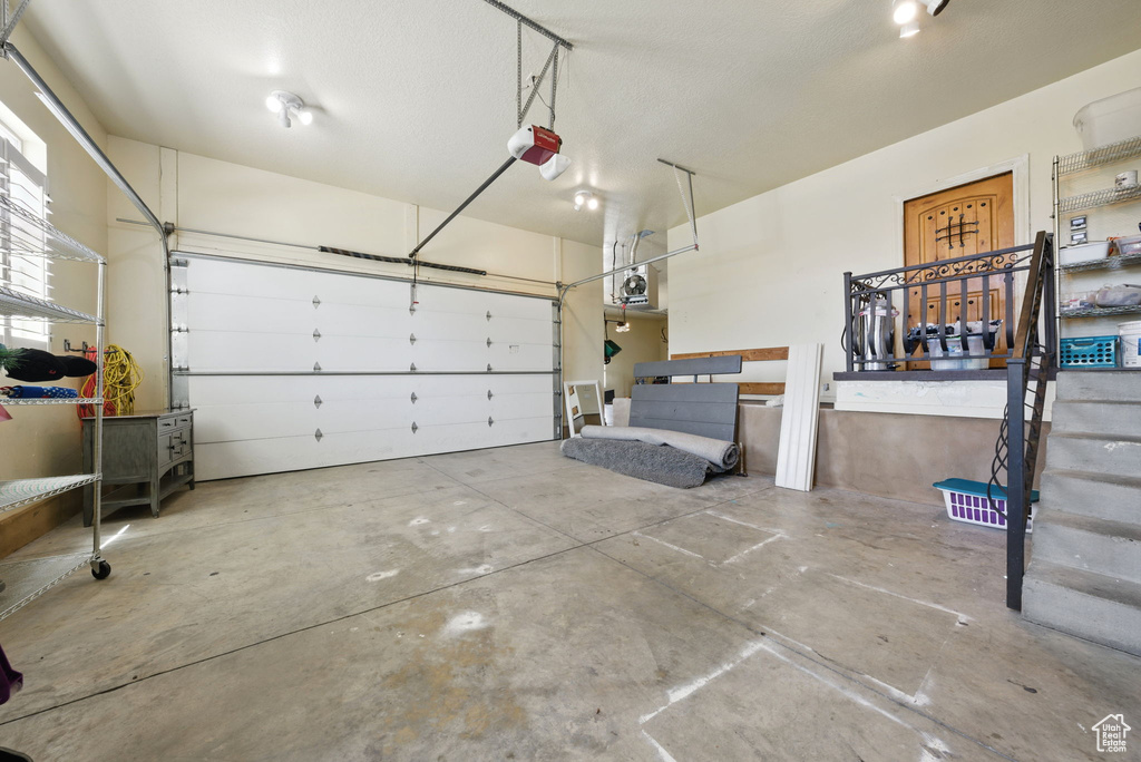 Garage with a garage door opener and a porch