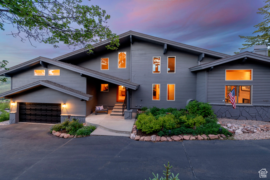 View of front of house with concrete driveway and an attached garage