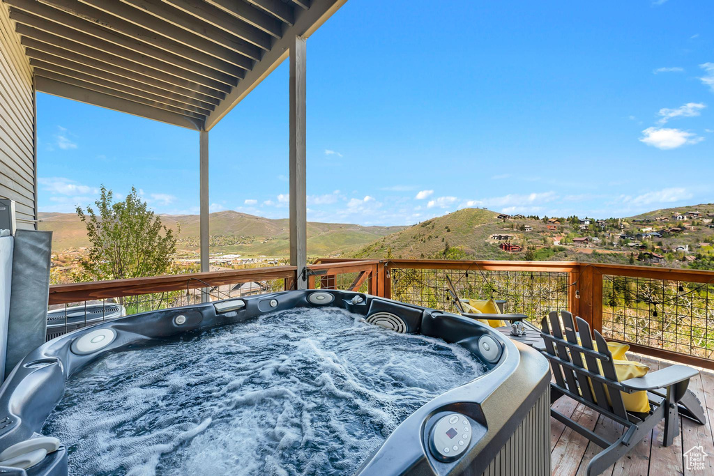 Wooden deck featuring a hot tub and a mountain view
