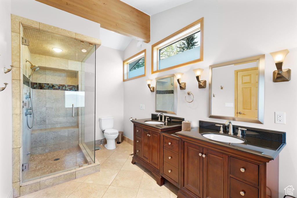 Full bathroom with double vanity, a stall shower, lofted ceiling, toilet, and tile patterned floors