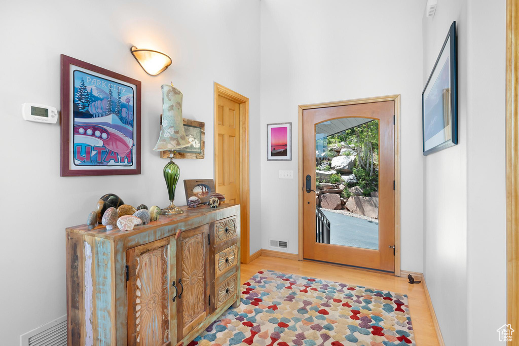 Foyer with light wood-type flooring and baseboards