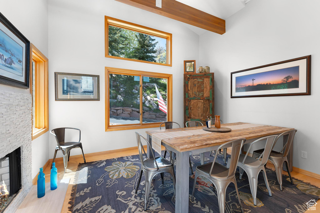 Dining room with wood finished floors, baseboards, and a fireplace