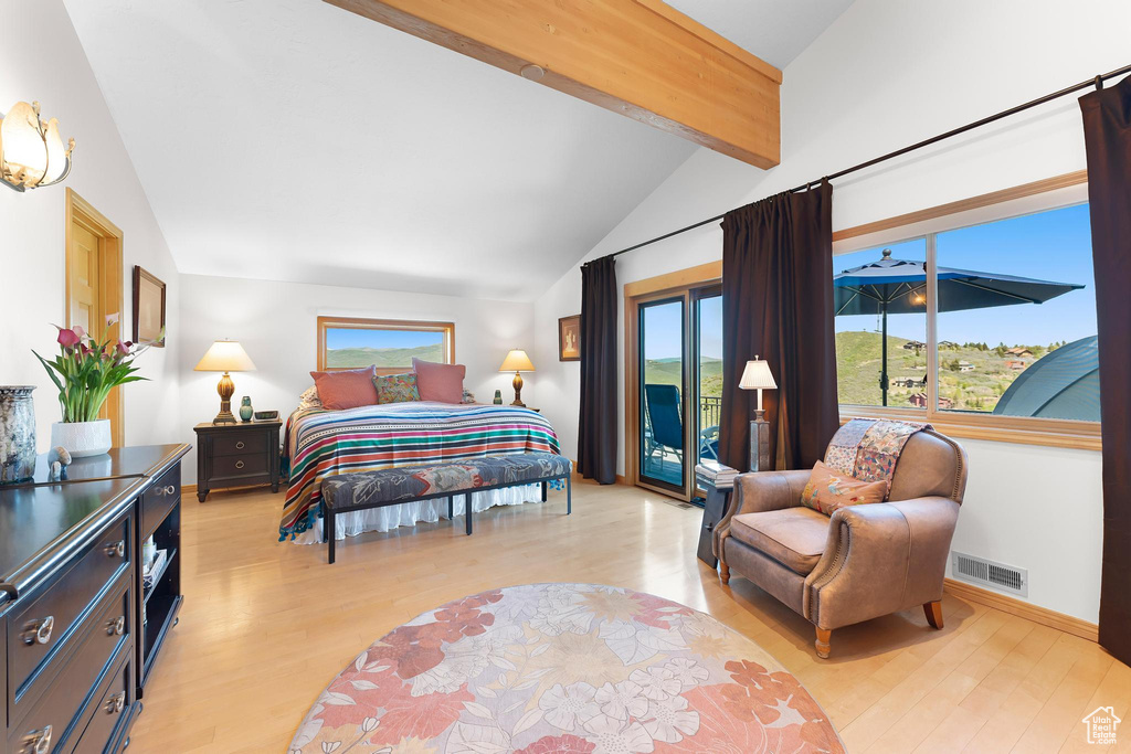 Bedroom with access to outside, light wood-type flooring, multiple windows, and baseboards