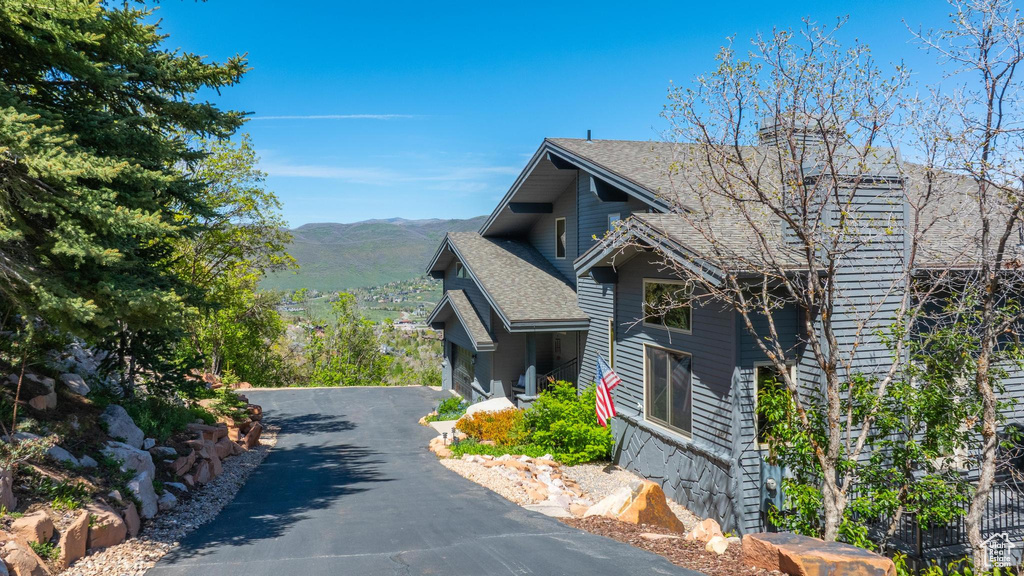 View of home\\\\\\\\\\\\\\\'s exterior featuring a mountain view, roof with shingles, and asphalt driveway