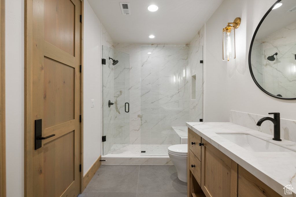 Full bath featuring toilet, a marble finish shower, vanity, and recessed lighting