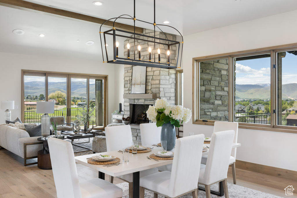 Dining area with light wood-style flooring, a mountain view, a chandelier, baseboards, and recessed lighting