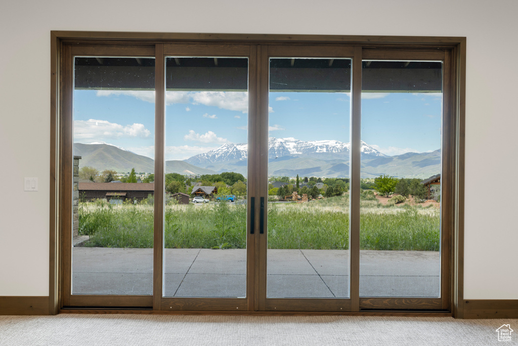 Doorway featuring a mountain view, carpet flooring, and baseboards