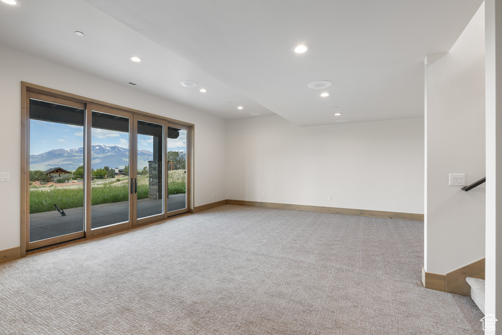 Empty room with carpet flooring, recessed lighting, baseboards, and stairs