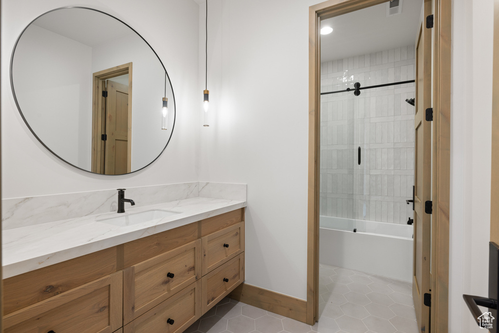 Bathroom with vanity, shower / tub combination, and tile patterned floors