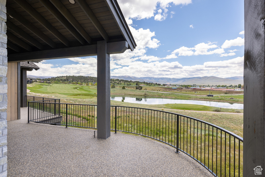 View of patio with a water and mountain view and view of golf course