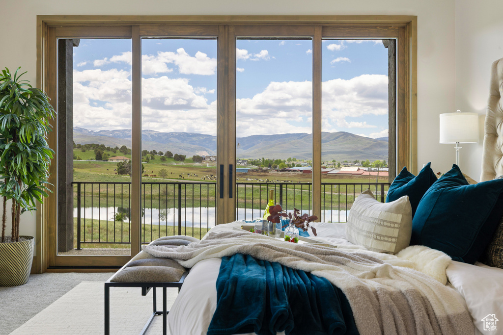 Carpeted bedroom with access to exterior and a mountain view