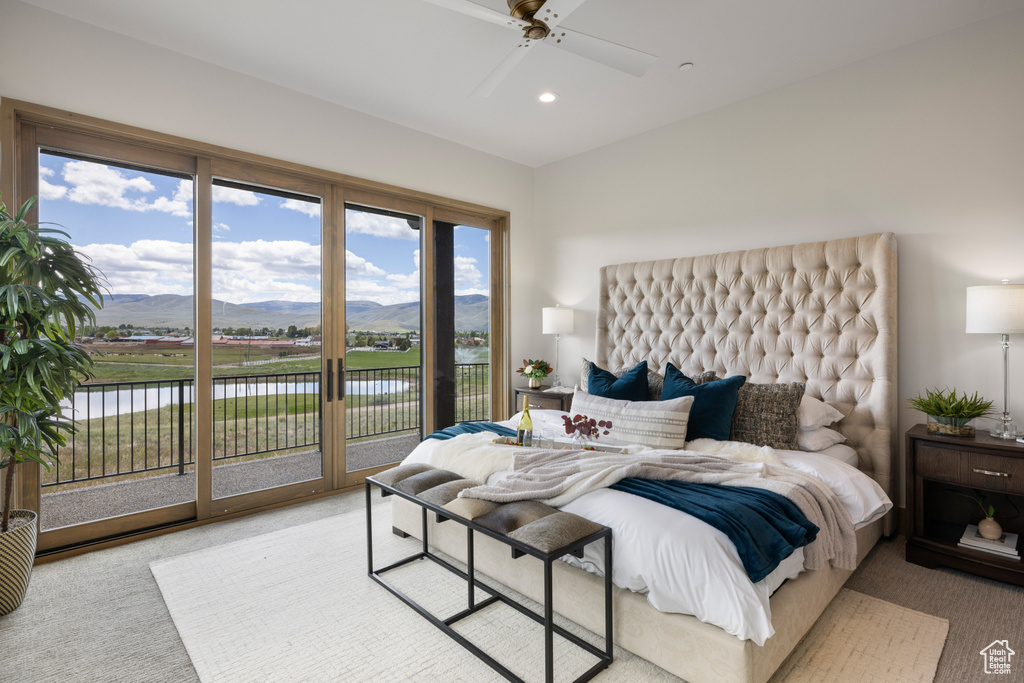 Bedroom with access to outside, a water and mountain view, light colored carpet, and recessed lighting
