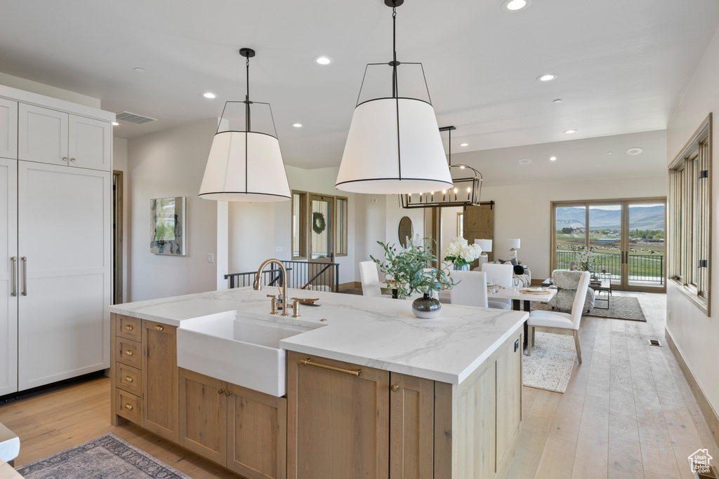 Kitchen with a sink, light wood-style floors, a kitchen island with sink, recessed lighting, and open floor plan