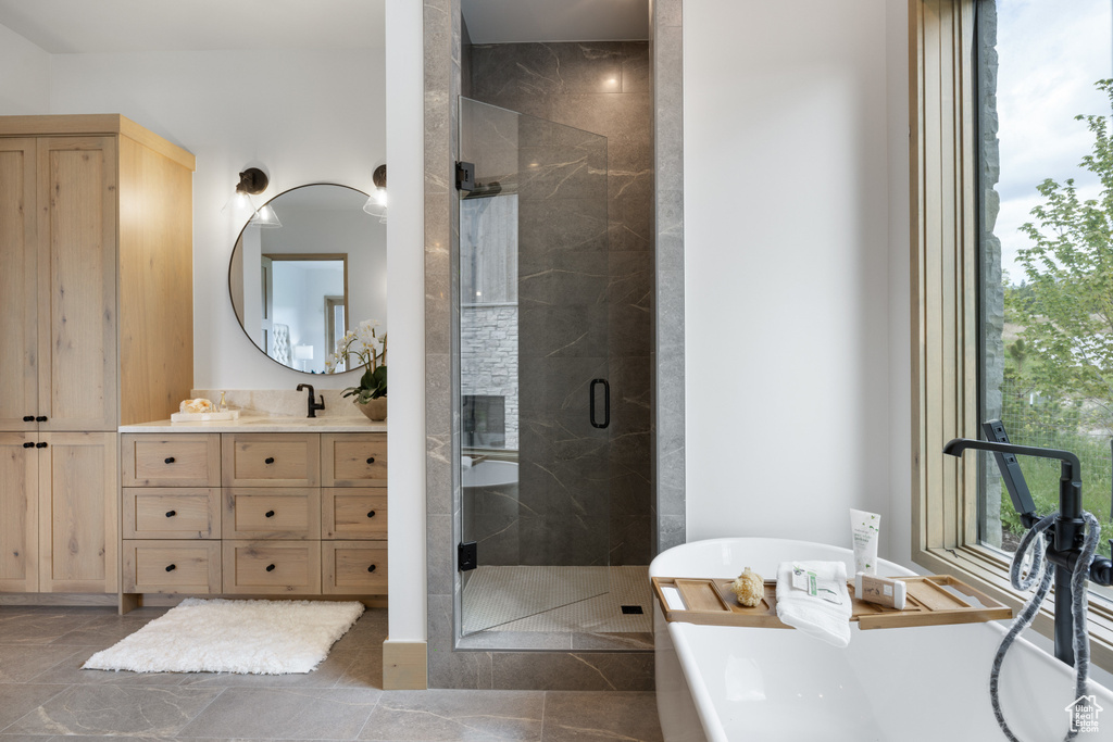 Bathroom with vanity, a shower stall, and a freestanding tub
