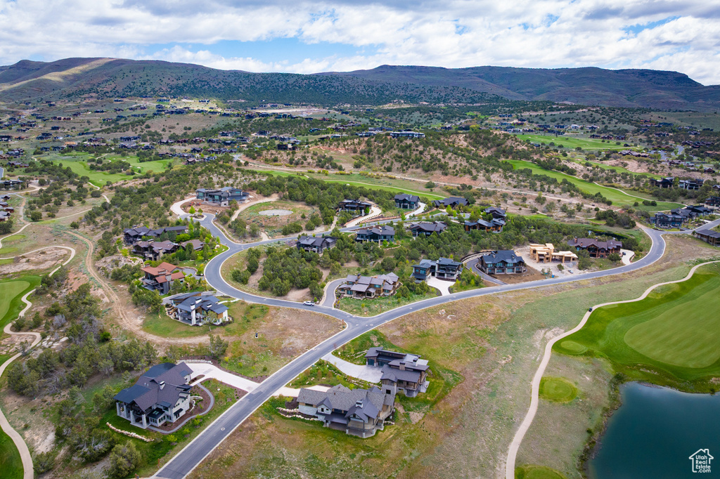 View of property location featuring nearby suburban area, a water and mountain view, and a local golf course