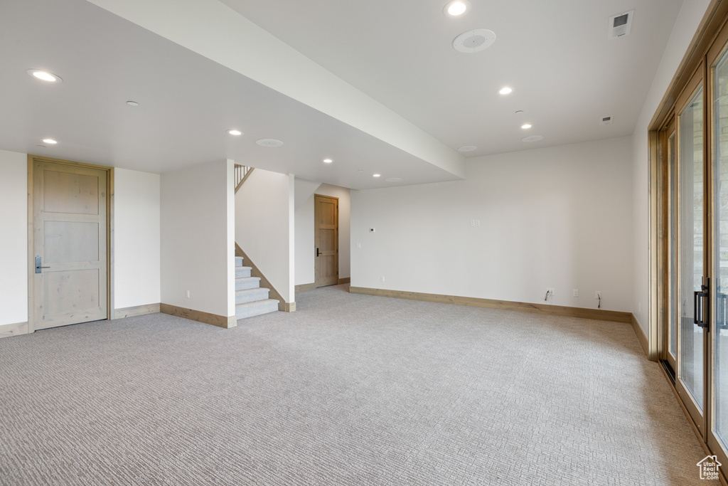 Unfurnished room with light colored carpet, recessed lighting, stairs, and baseboards