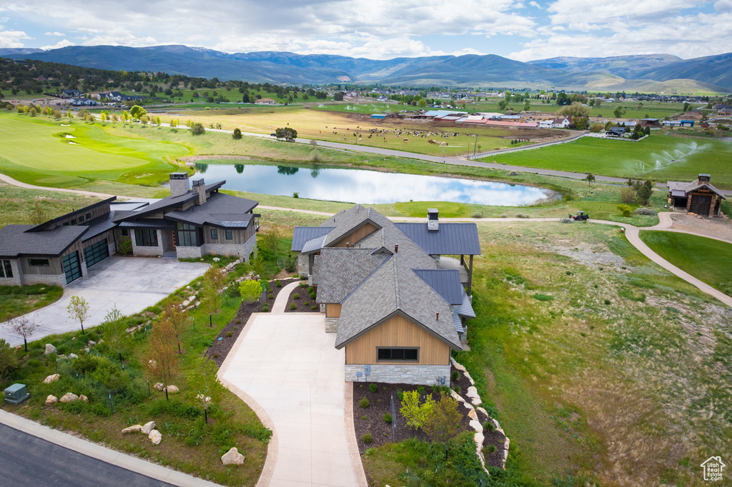 Aerial view of property and surrounding area featuring a water and mountain view and a local golf course