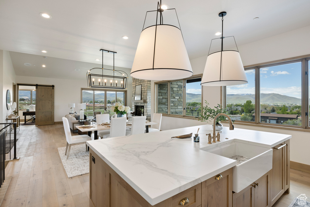Kitchen with a sink, a barn door, open floor plan, light wood-type flooring, and recessed lighting