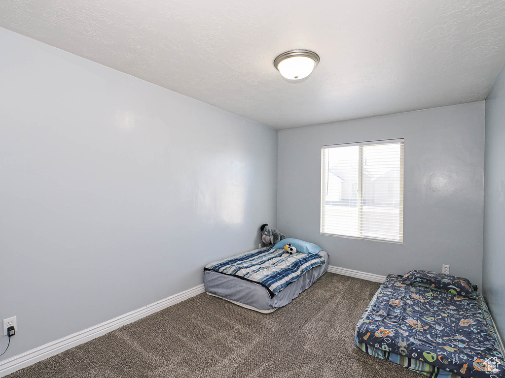 Unfurnished bedroom with baseboards and carpet flooring
