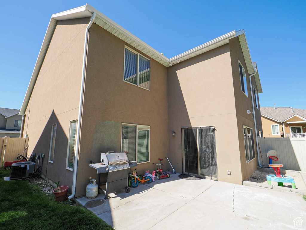Back of property with stucco siding, a patio area, and central air condition unit