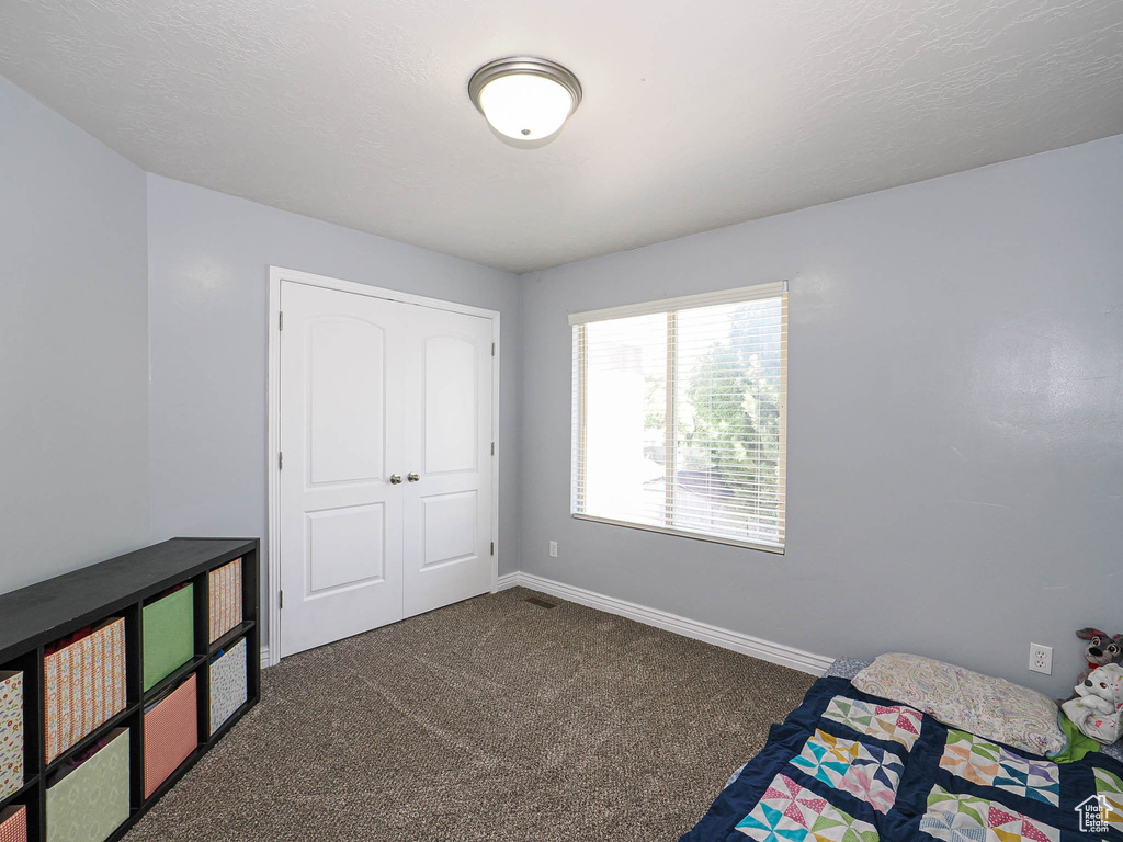 Bedroom with dark carpet and baseboards