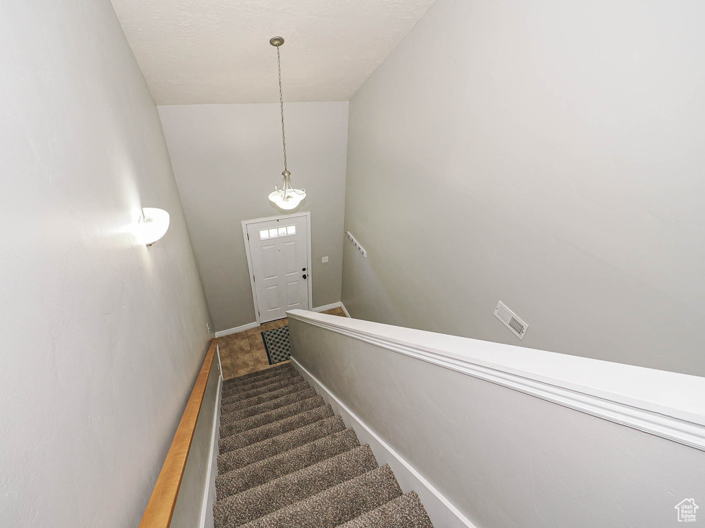 Stairway with lofted ceiling and baseboards