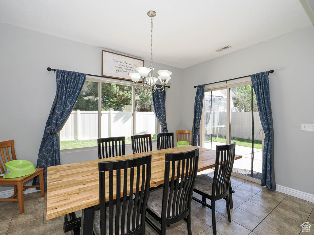 Dining room featuring a chandelier and baseboards