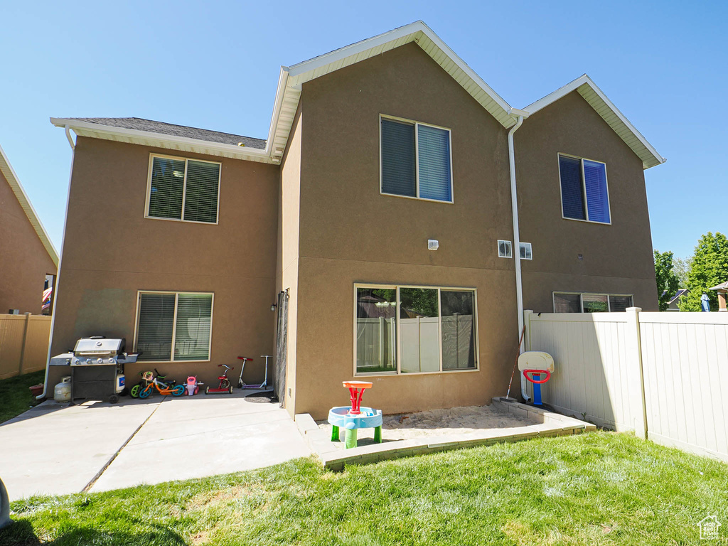 Rear view of property with stucco siding and a patio