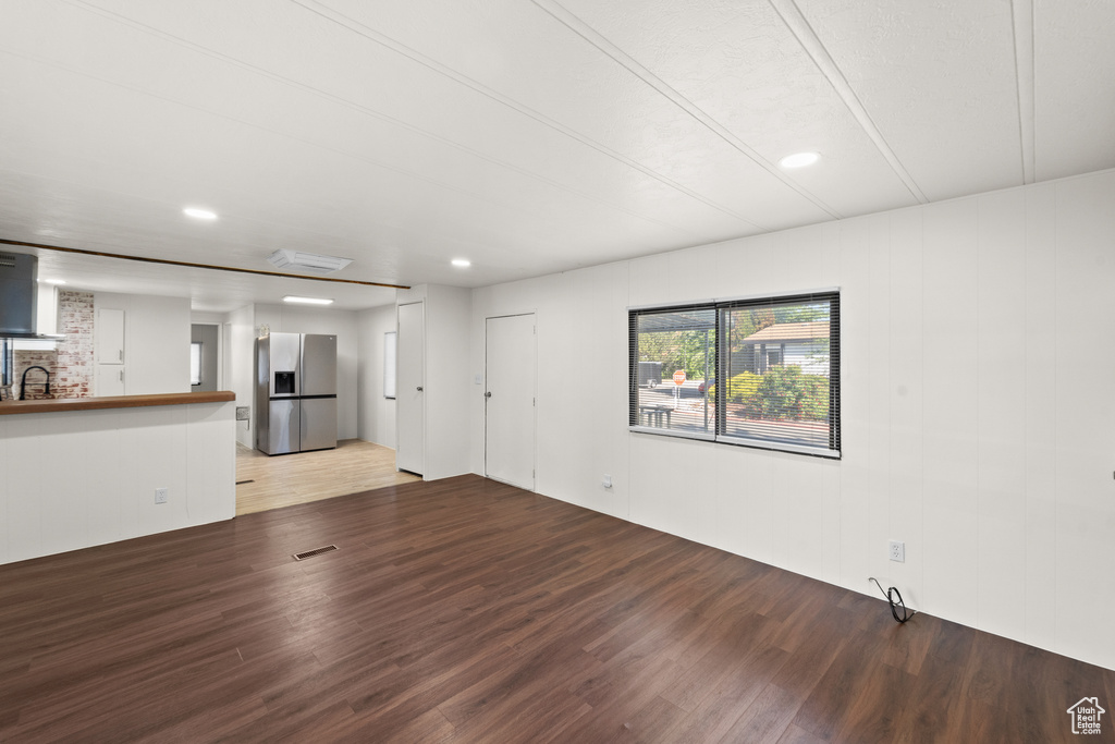 Unfurnished living room with light wood-style floors, a sink, and recessed lighting