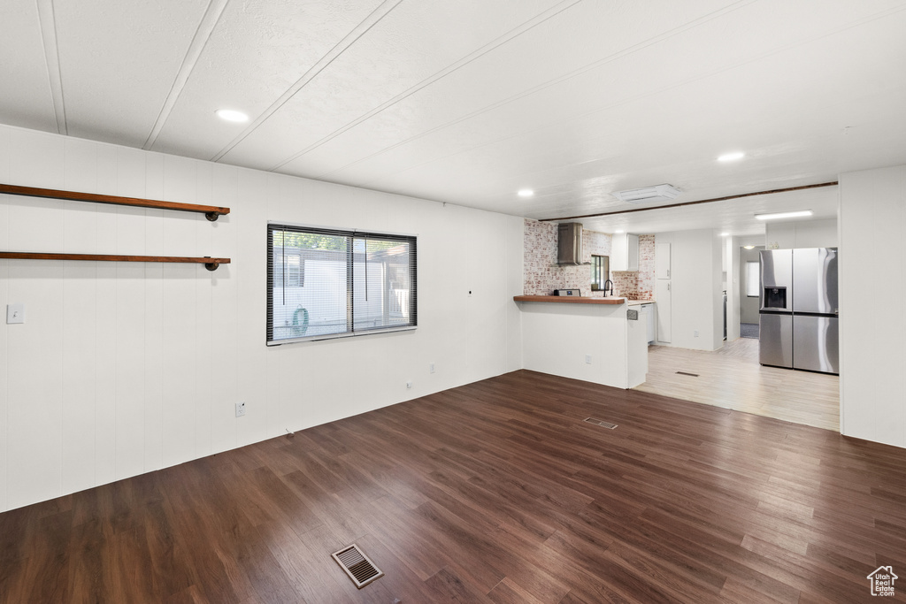 Unfurnished living room with wood finished floors and recessed lighting