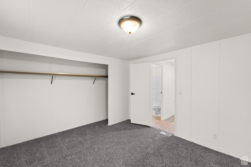 Unfurnished bedroom featuring carpet flooring and a closet