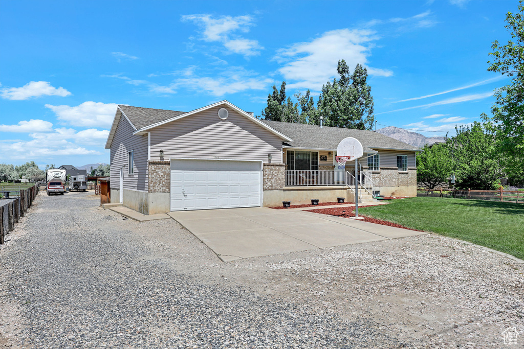 View of front of home with driveway, an attached garage, and roof with shingles