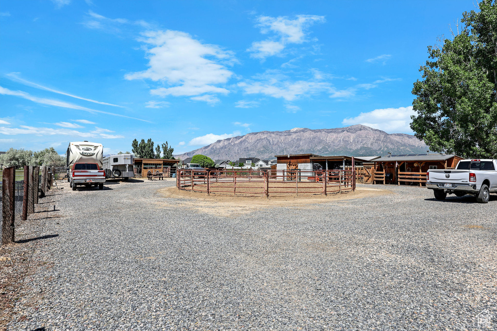 View of dirt / gravel road with a mountain view and an exterior structure