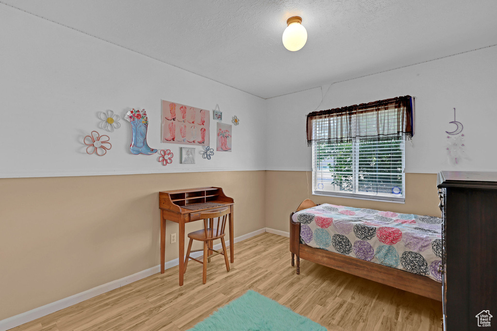 Bedroom featuring wood finished floors and baseboards