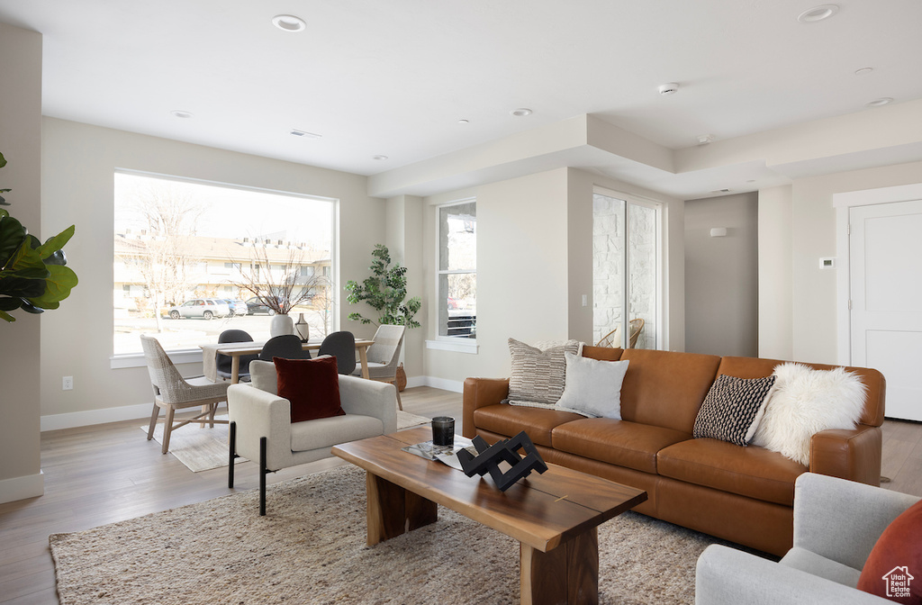 Living area featuring baseboards, light wood-style floors, and recessed lighting