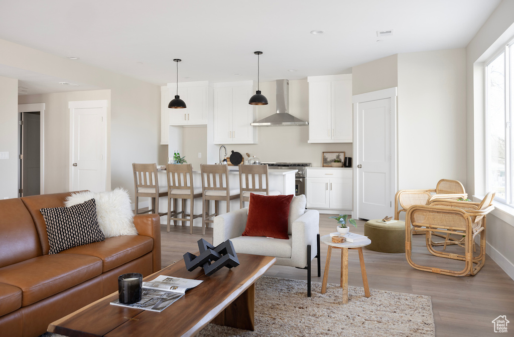 Living room featuring light wood-type flooring, healthy amount of natural light, and baseboards