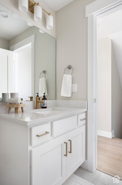 Bathroom with vanity, tile patterned flooring, and baseboards