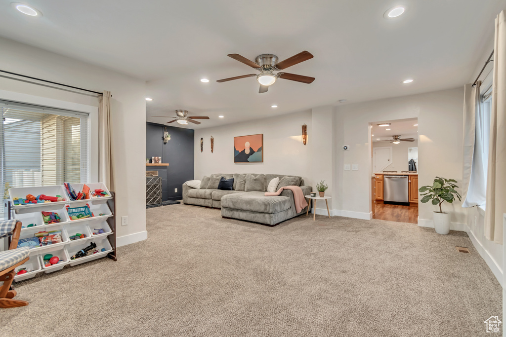 Living room with carpet flooring, a ceiling fan, recessed lighting, a fireplace, and baseboards