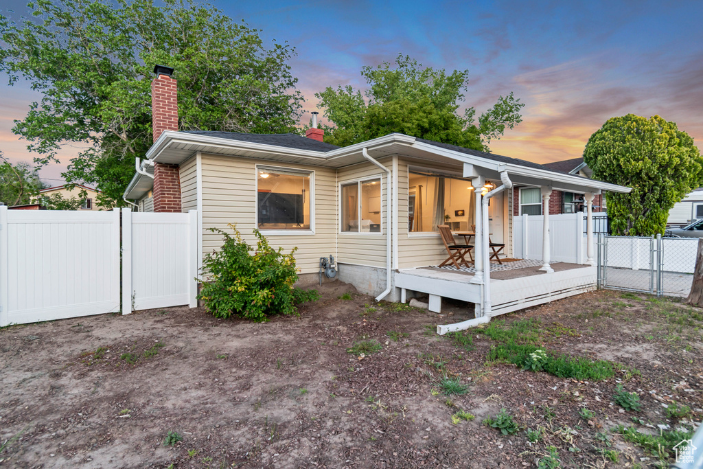 View of front of home featuring a chimney, a deck, and a gate