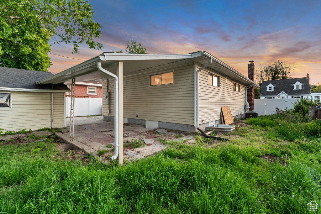 Back of property at dusk with a patio area