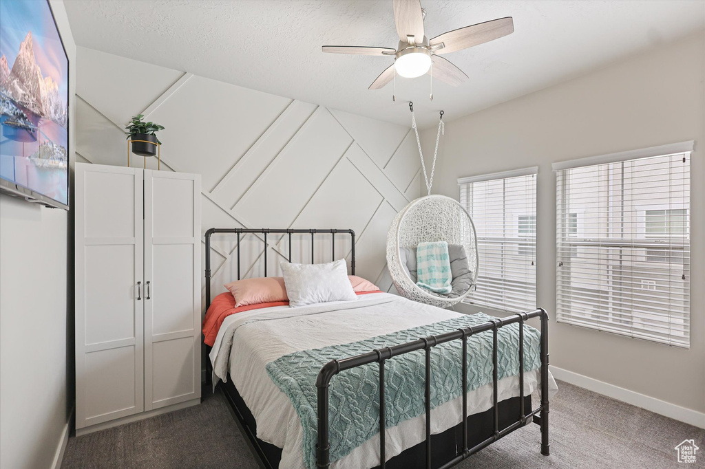 Bedroom with carpet, baseboards, and a ceiling fan
