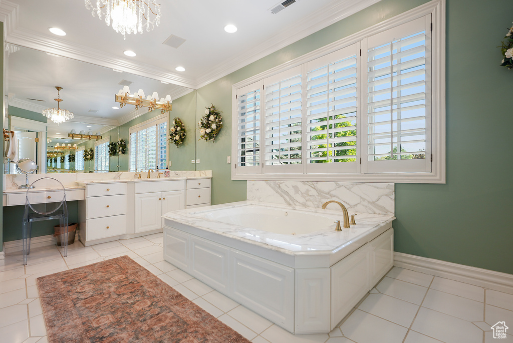 Bathroom with a chandelier, a garden tub, vanity, crown molding, and tile patterned flooring